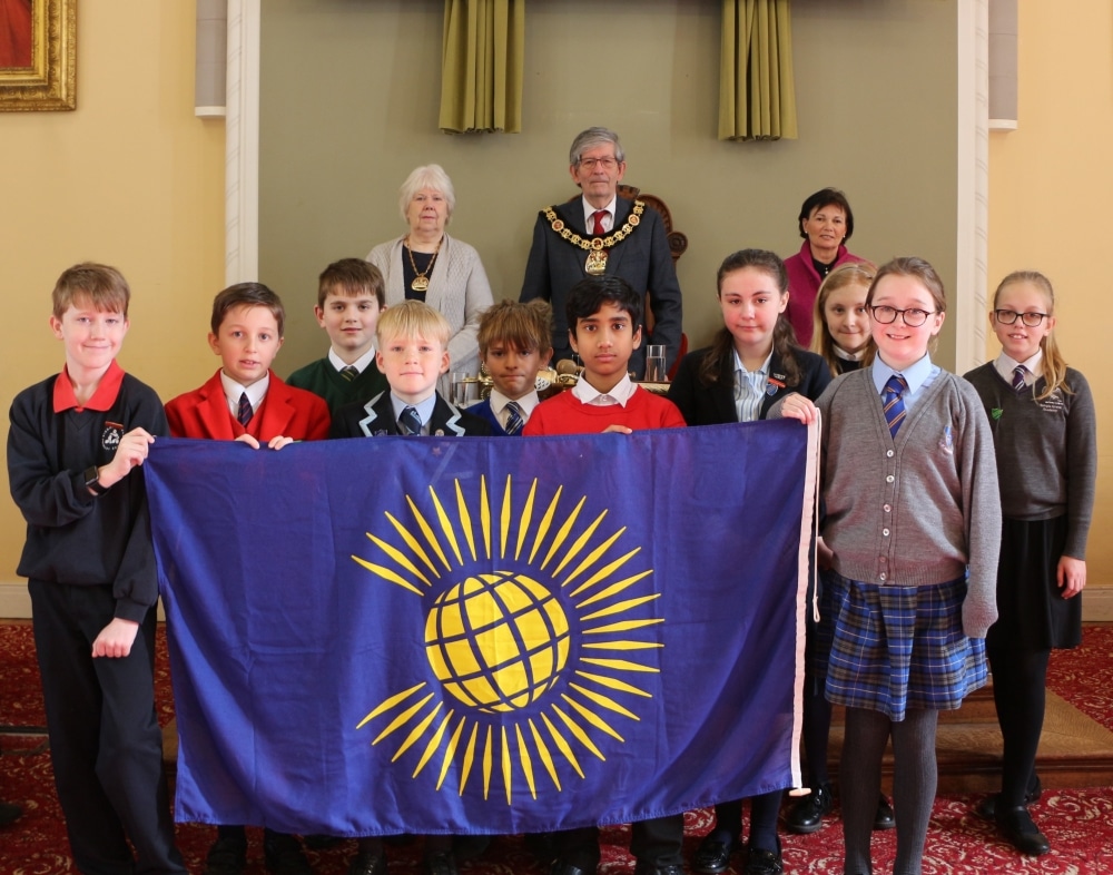 Children raise the flag for Commonwealth Day