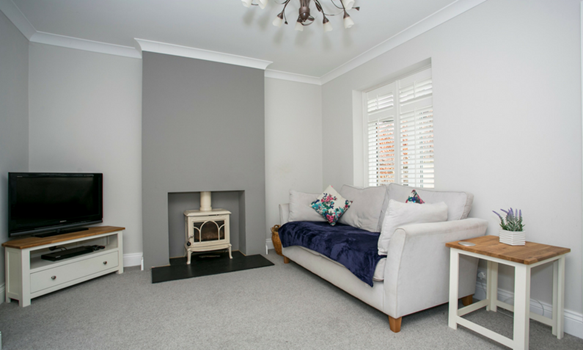 The stylish living room features a cosy stove